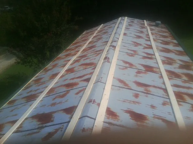 Rusted metal roof panels with new wood purlins before replacement — Storm Damage Roof Repair in Montpelier by Roofing Brothers